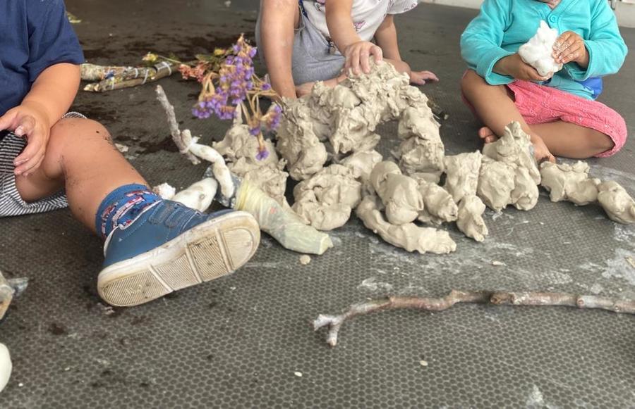 Kinderen spelen met klei en stokken tijdens de voorstelling van Theater de Spiegel Kinderen spelen met klei en stokken tijdens de voorstelling van Theater de Spiegel